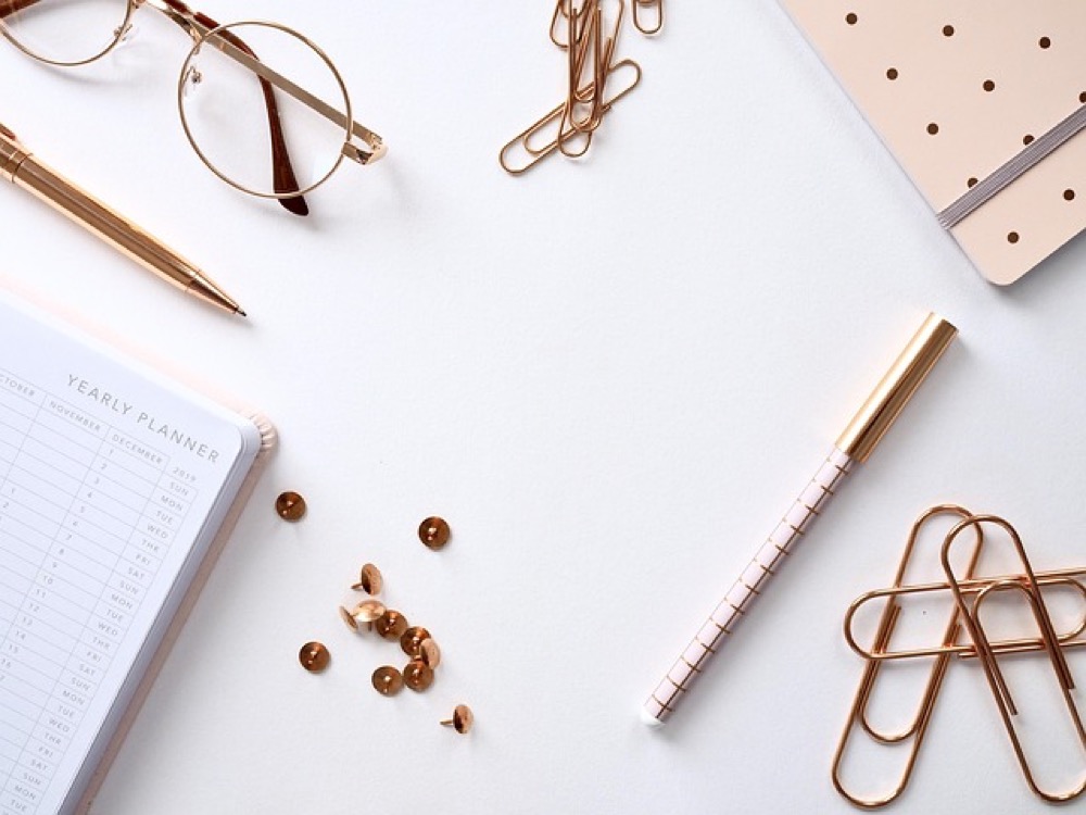 Uporządkowane biurko z notatnikiem i akcesoriami w stylu flat lay