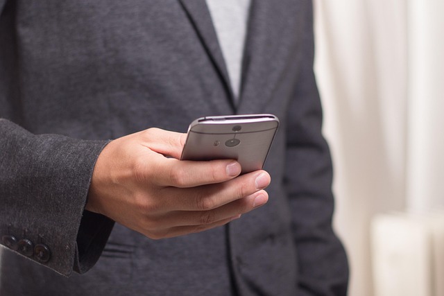 Biznesmen wysyła wiadomość na smartfonie — profesjonalny outreach B2B na LinkedIn