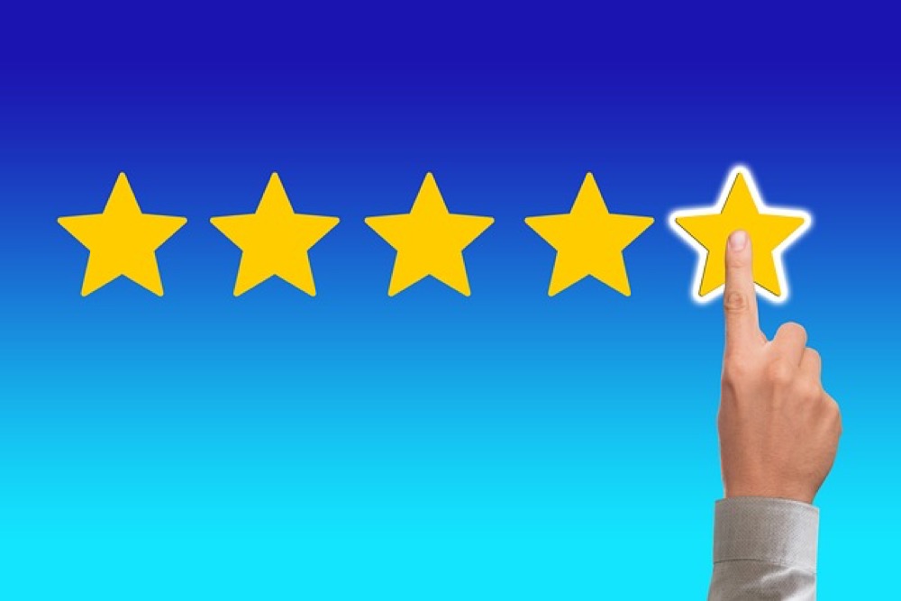 Osoba trzymająca smartfon z widoczną oceną w postaci gwiazdek