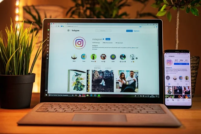 Laptop ze stroną Instagram obok smartfona z aplikacją społecznościową
